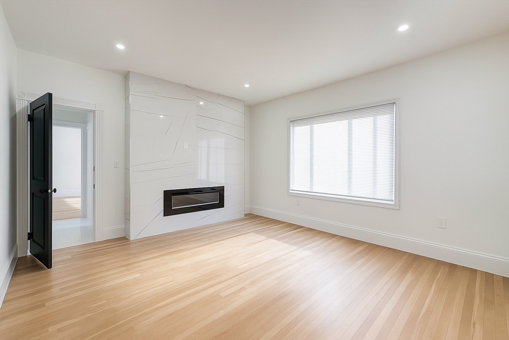 70 Nelson Street, Unit 2 Boston, MA 02124 - Photo 4 of 12 an empty room with windows and a fireplace