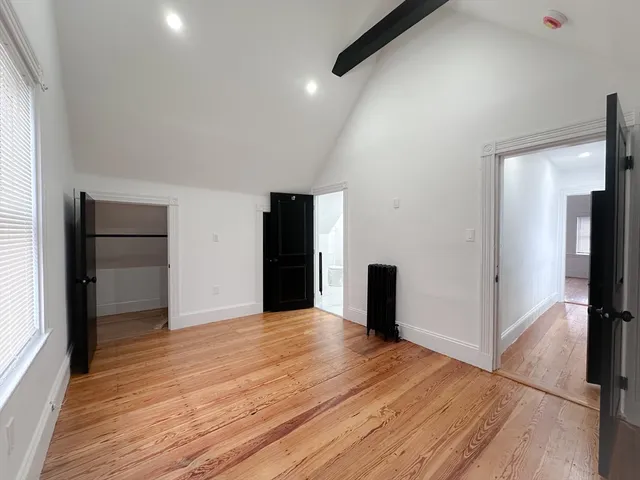 a view of a kitchen with wooden floor and a refrigerator