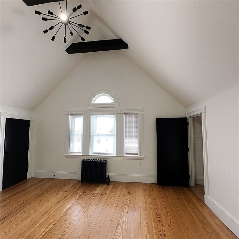 70 Nelson Street, Unit 2 Boston, MA 02124 - Photo 10 of 12 an empty room with wooden floor cabinet and windows