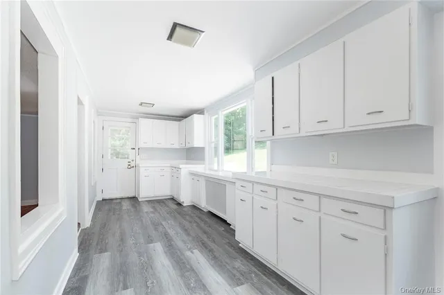 a kitchen with white cabinets and sink