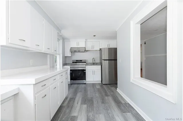 a kitchen with white cabinets and stainless steel appliances