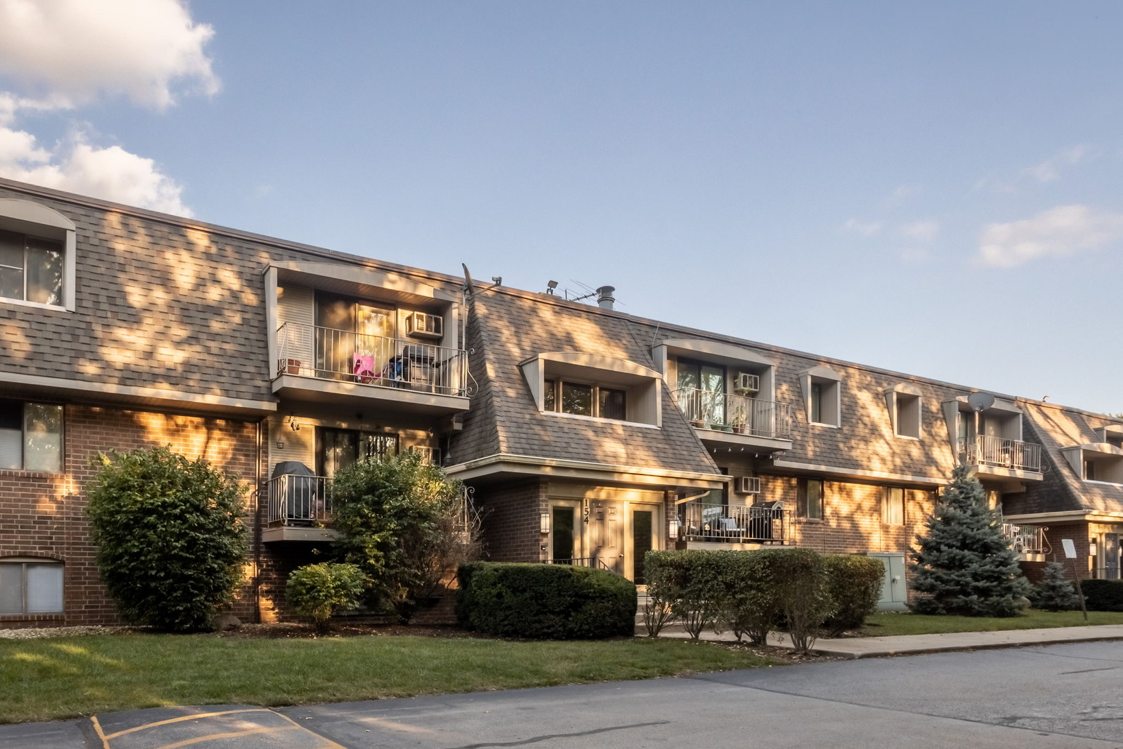154 East Bailey Road, Unit F Naperville, IL 60565 - Photo 23 of 25 a front view of a building with a garden and plants