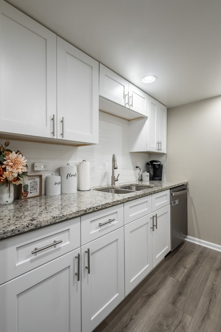 154 East Bailey Road, Unit F Naperville, IL 60565 - Photo 9 of 25 a kitchen with granite countertop white cabinets and white appliances