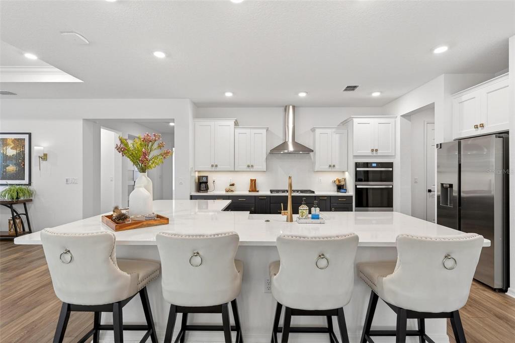 9746 Southwest 108th Terrace Road Ocala, FL 34481 - Photo 24 of 99 a kitchen with stainless steel appliances kitchen island granite countertop a dining table chairs refrigerator and sink