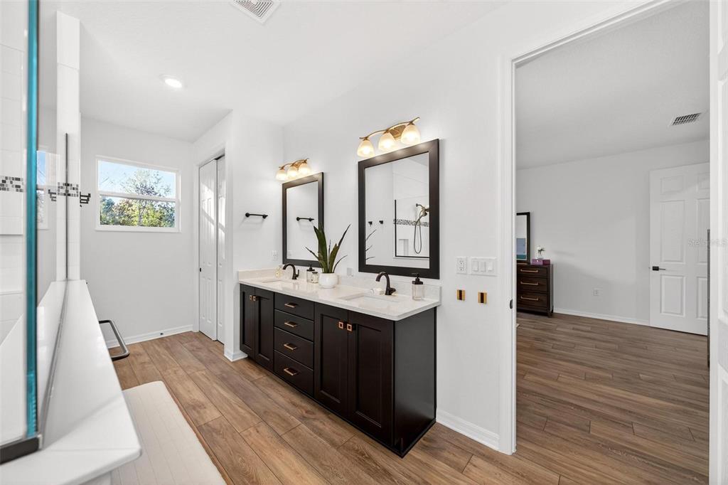 9746 Southwest 108th Terrace Road Ocala, FL 34481 - Photo 52 of 99 a spacious bathroom with a double vanity sink and a mirror