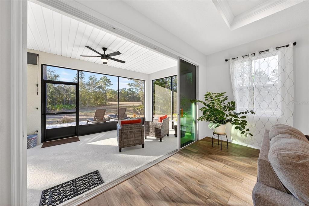 9746 Southwest 108th Terrace Road Ocala, FL 34481 - Photo 81 of 99 a living room with furniture and a large window with wooden floor