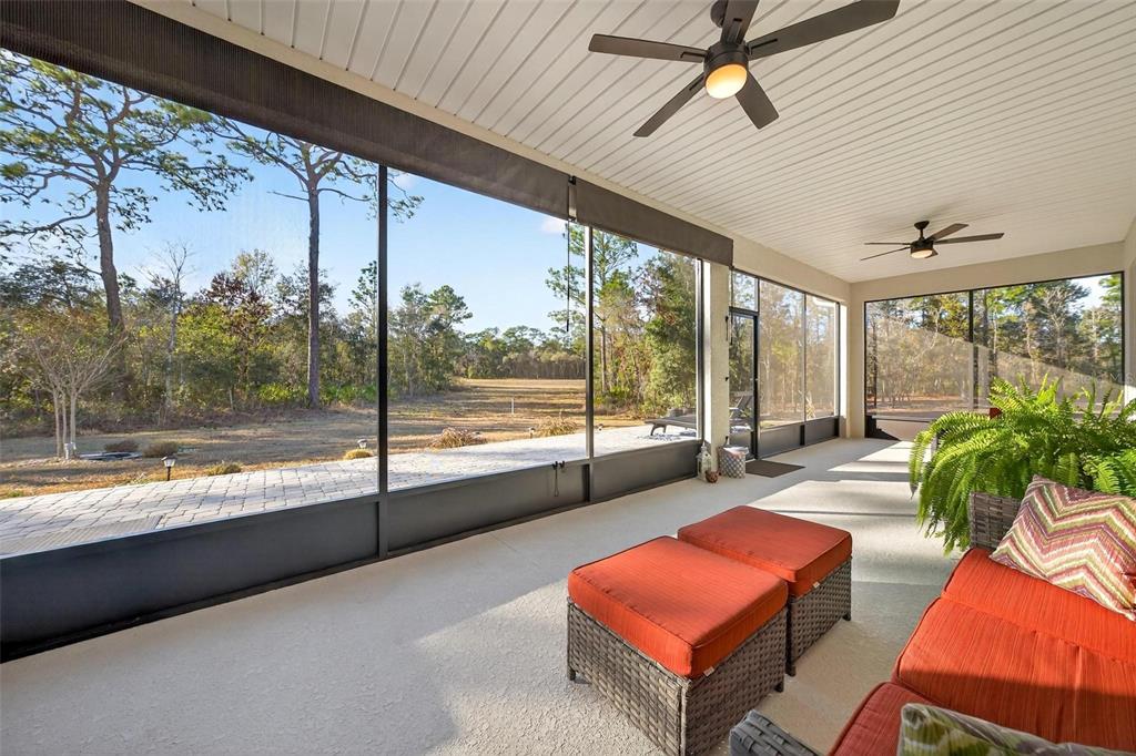 9746 Southwest 108th Terrace Road Ocala, FL 34481 - Photo 84 of 99 a living room with patio furniture and a floor to ceiling window
