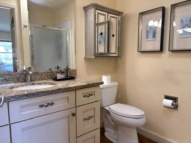 404 Feltham Trail, Unit B Sun City Center, FL 33573 - Photo 43 of 59 a bathroom with a granite countertop toilet sink and mirror