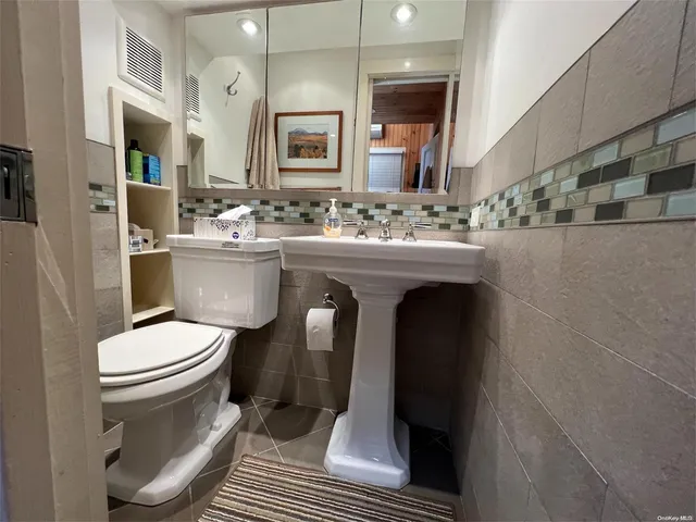 a bathroom with a sink toilet and mirror