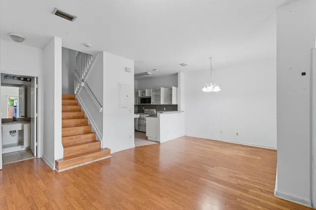 a view of a kitchen with wooden floor and electronic appliances