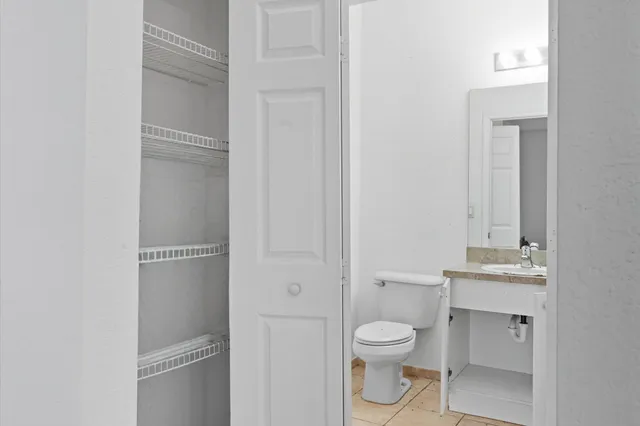 a bathroom with a toilet sink vanity and mirror