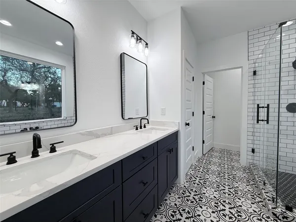 a large kitchen with stainless steel appliances a large counter top and a refrigerator