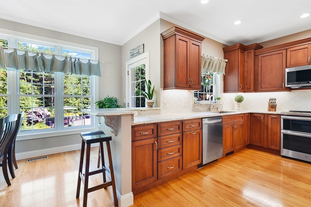 24 Two Ponds Road Belchertown, MA 01007 - Photo 15 of 41 a kitchen with stainless steel appliances granite countertop sink microwave and wooden cabinets