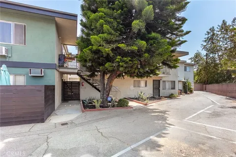 a view of a house with a tree and a large parking space