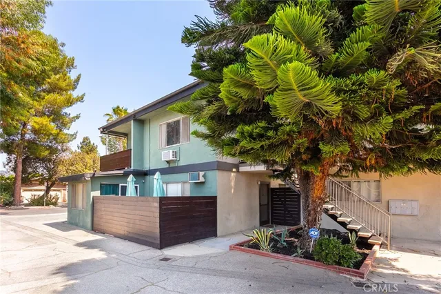 a front view of a house with a tree