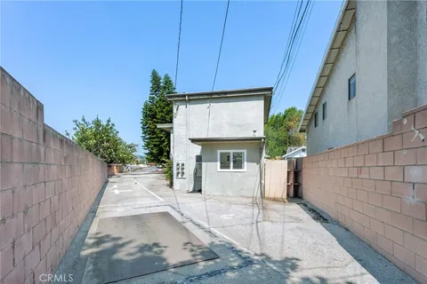 a view of a white house with a small yard and plants