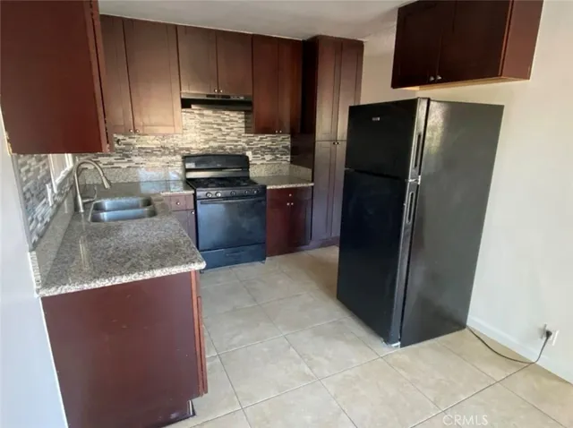 a kitchen with stainless steel appliances granite countertop a refrigerator stove and sink