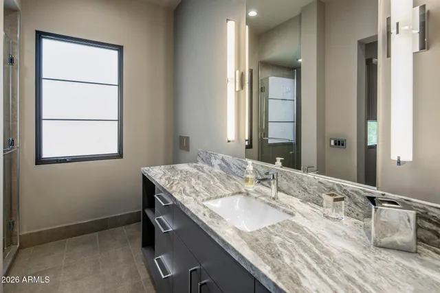 a bathroom with a granite countertop sink and a mirror