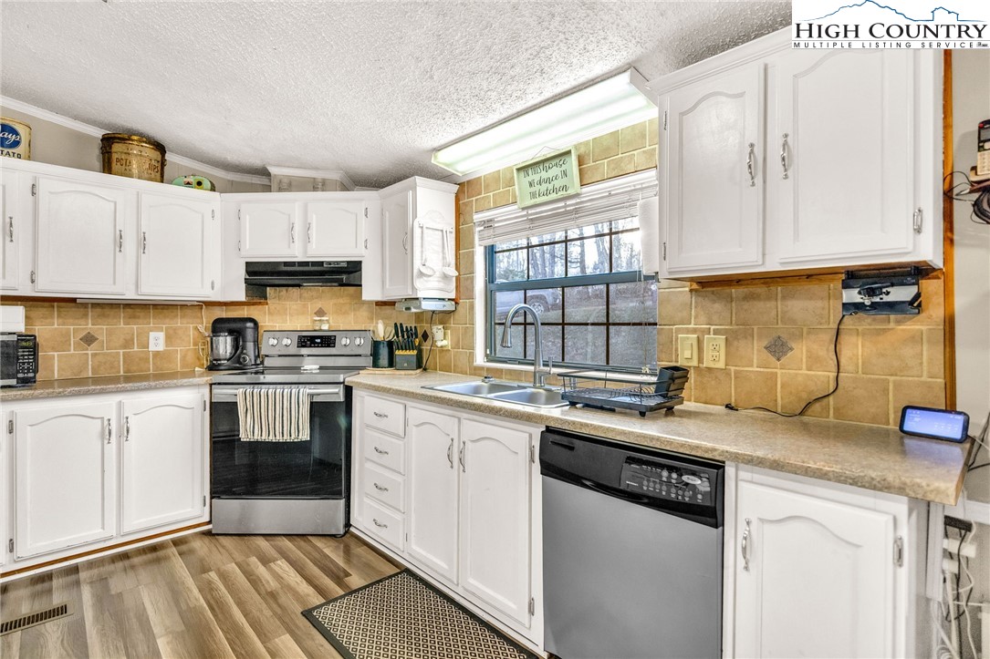 747 Nathans Creek School Road Crumpler, NC 28617 - Photo 13 of 42 a kitchen with a sink stove top oven and microwave