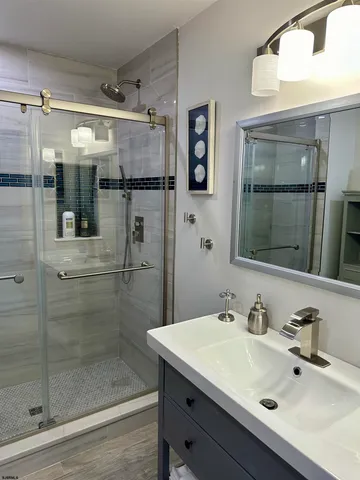 a bathroom with a shower sink and mirror