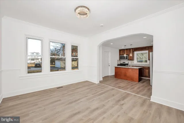 a kitchen with stainless steel appliances granite countertop a refrigerator a stove top oven a sink and dishwasher with wooden floor