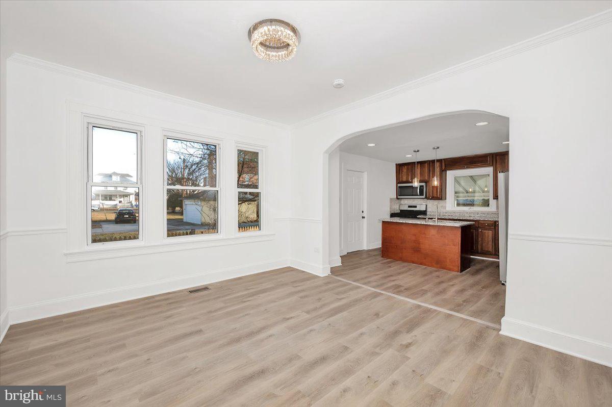 3503 Garrison Boulevard Baltimore, MD 21215 - Photo 12 of 68 a view of kitchen and empty room with wooden floor