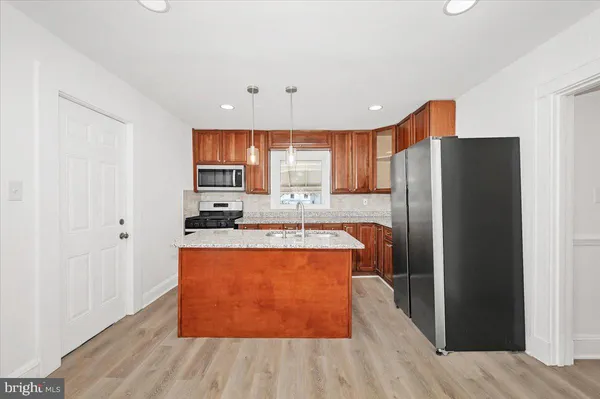 a kitchen with stainless steel appliances granite countertop a refrigerator a sink and a microwave