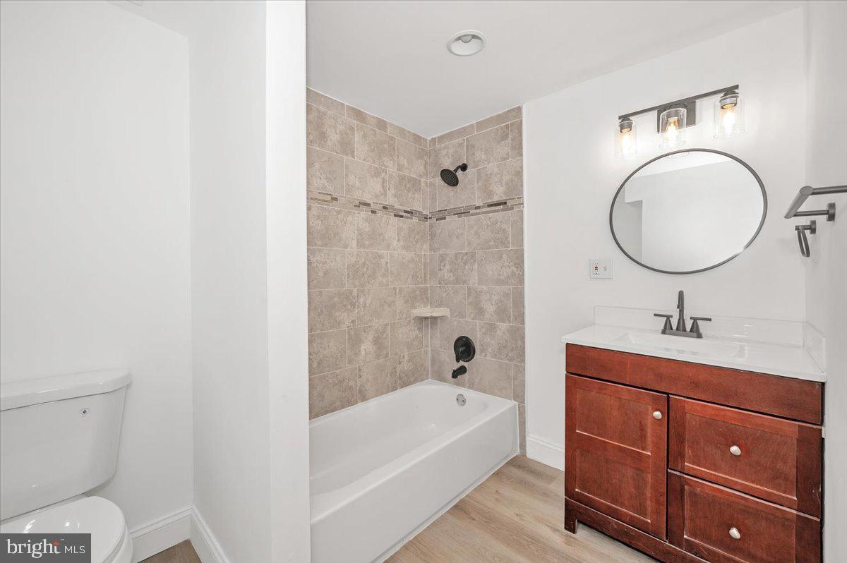 3503 Garrison Boulevard Baltimore, MD 21215 - Photo 25 of 68 a bathroom with a granite countertop toilet a sink and a bathtub