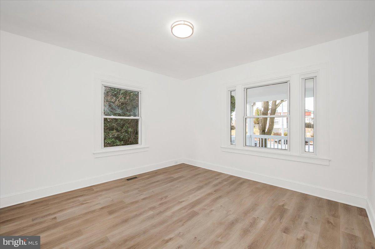 3503 Garrison Boulevard Baltimore, MD 21215 - Photo 26 of 68 an empty room with wooden floor and windows