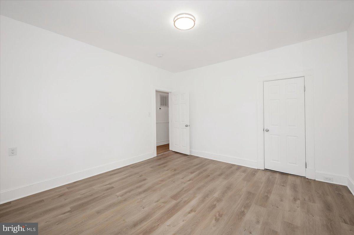 3503 Garrison Boulevard Baltimore, MD 21215 - Photo 27 of 68 an empty room with wooden floor and windows