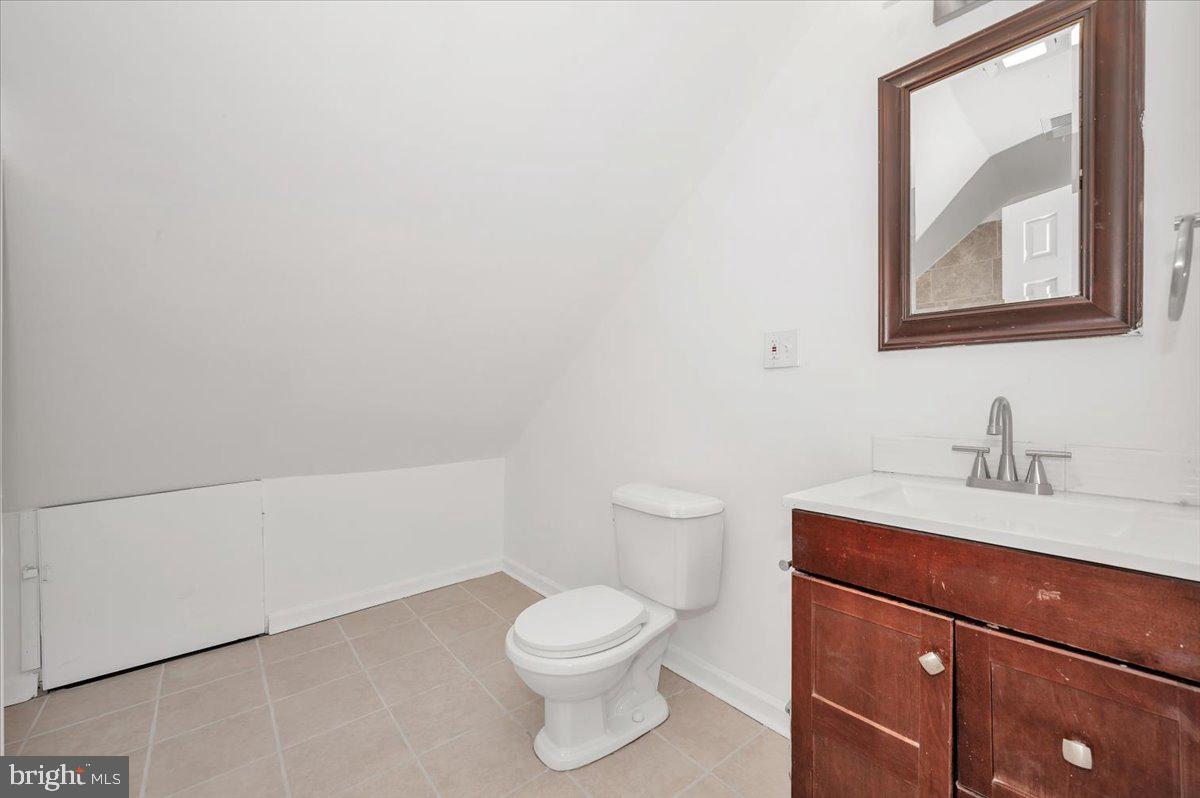 3503 Garrison Boulevard Baltimore, MD 21215 - Photo 44 of 68 a bathroom with a toilet a sink and mirror