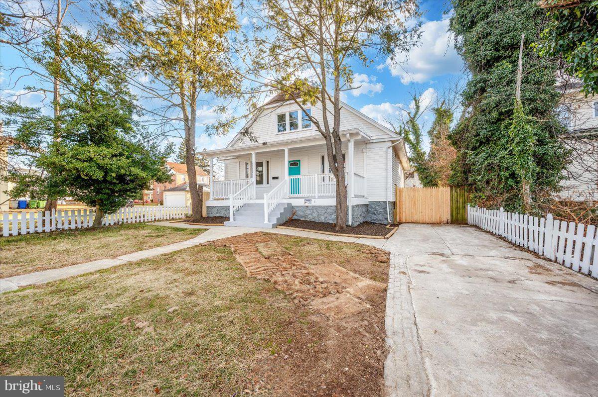 3503 Garrison Boulevard Baltimore, MD 21215 - Photo 67 of 68 a view of a white house with a large tree with wooden fence