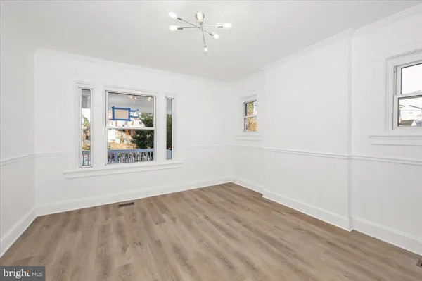 an empty room with wooden floor and ceiling fan
