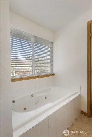 a bathroom with bathtub and window