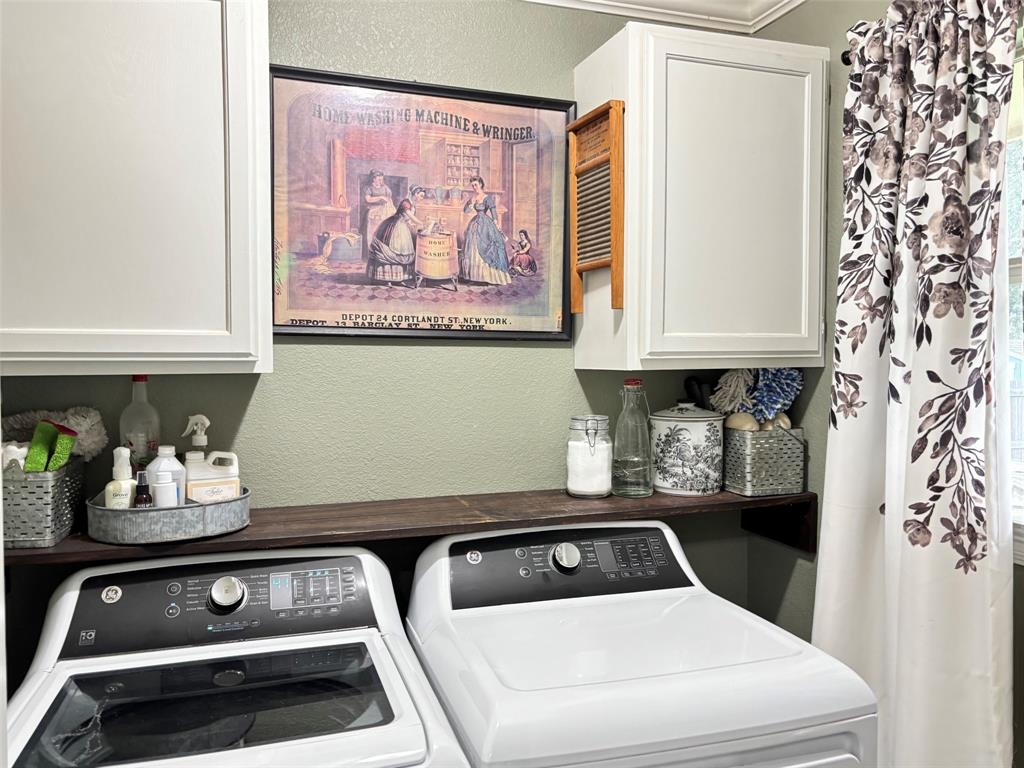 605 Jade Haughton, LA 71037 - Photo 21 of 34 Dedicated laundry space featuring a wood-finish sheleve, upper white cabinetry, and a floral-patterned curtain