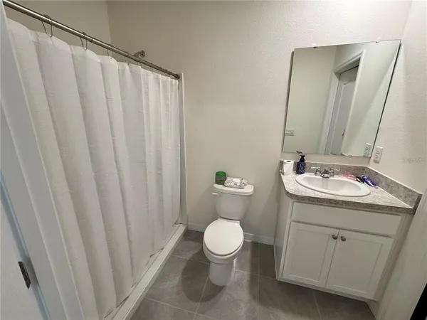 a bathroom with a granite countertop sink toilet and a mirror