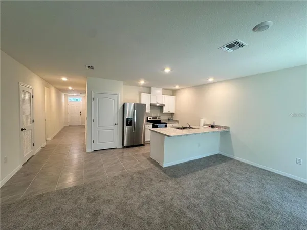 a view of an empty room with kitchen