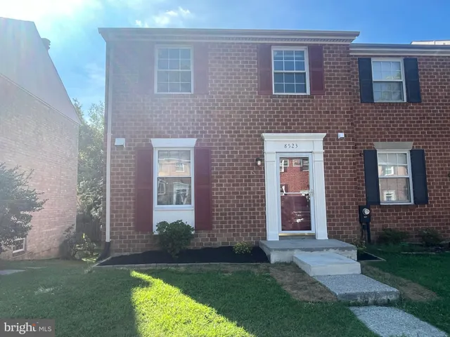 front view of a brick house and a yard