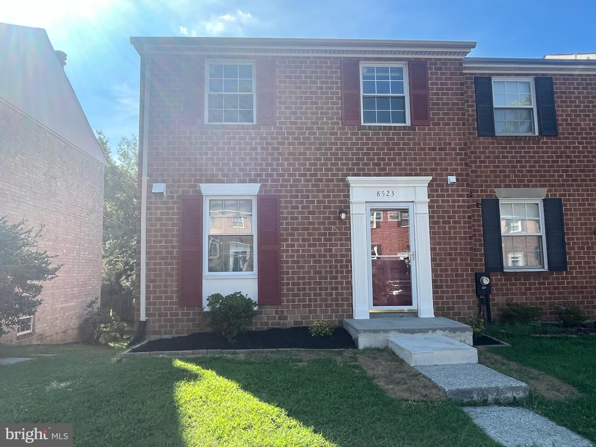front view of a brick house and a yard