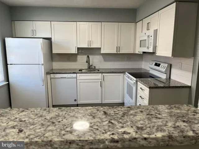 a kitchen with stainless steel appliances granite countertop a refrigerator sink and cabinets