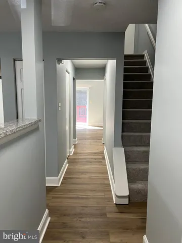 a view of hallway with stairs and wooden floor