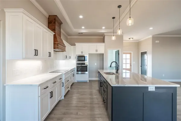 a large kitchen with kitchen island a sink a counter space stainless steel appliances and cabinets