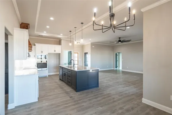 a kitchen with a stove a window and wooden floor