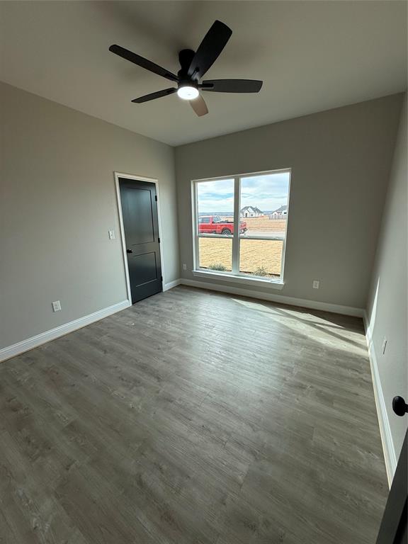 239 Indian Ridge Road Tuscola, TX 79562 - Photo 20 of 26 an empty room with wooden floor fan and windows