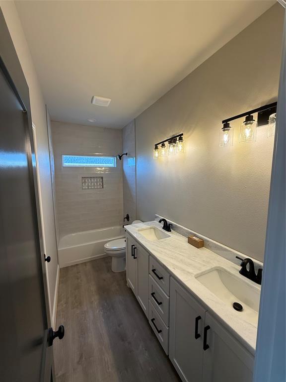 239 Indian Ridge Road Tuscola, TX 79562 - Photo 24 of 26 a bathroom with a granite countertop sink a toilet a mirror and shower