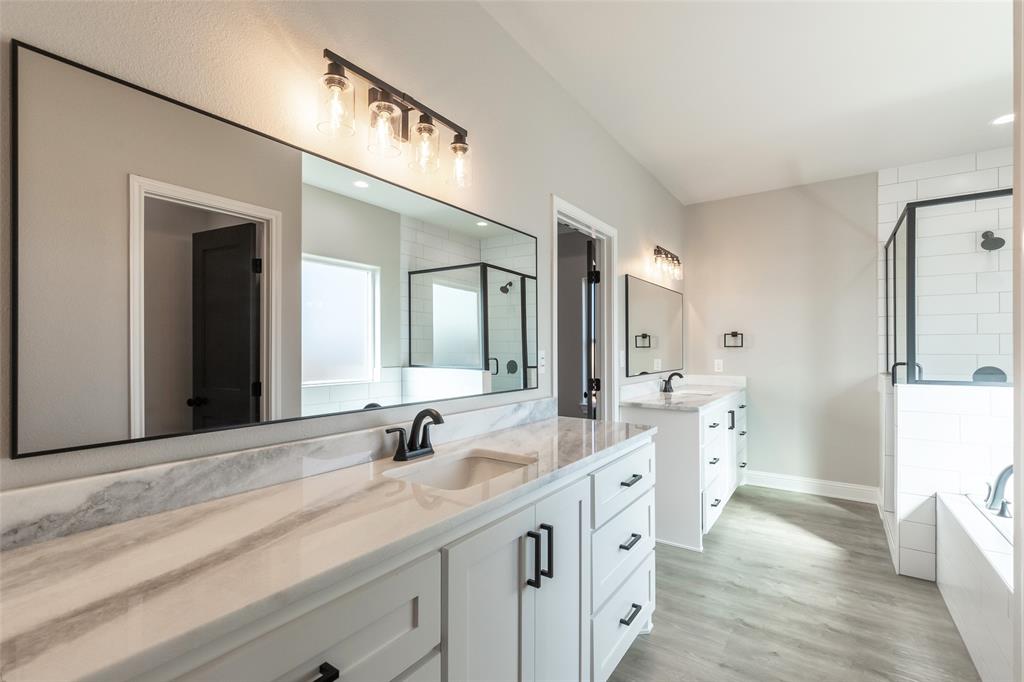 239 Indian Ridge Road Tuscola, TX 79562 - Photo 9 of 37 a spacious bathroom with a double vanity sink a mirror and a shower