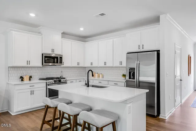 a kitchen with stainless steel appliances granite countertop a sink stove and refrigerator