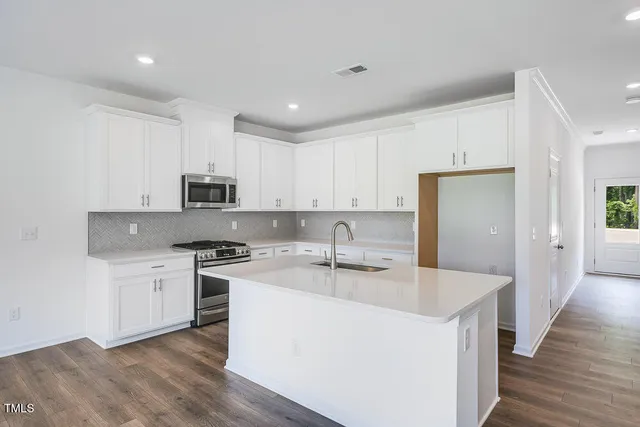 a kitchen with granite countertop a sink and stove top oven