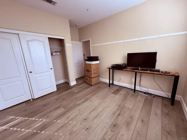 a view of a livingroom with wooden floor and a flat screen tv