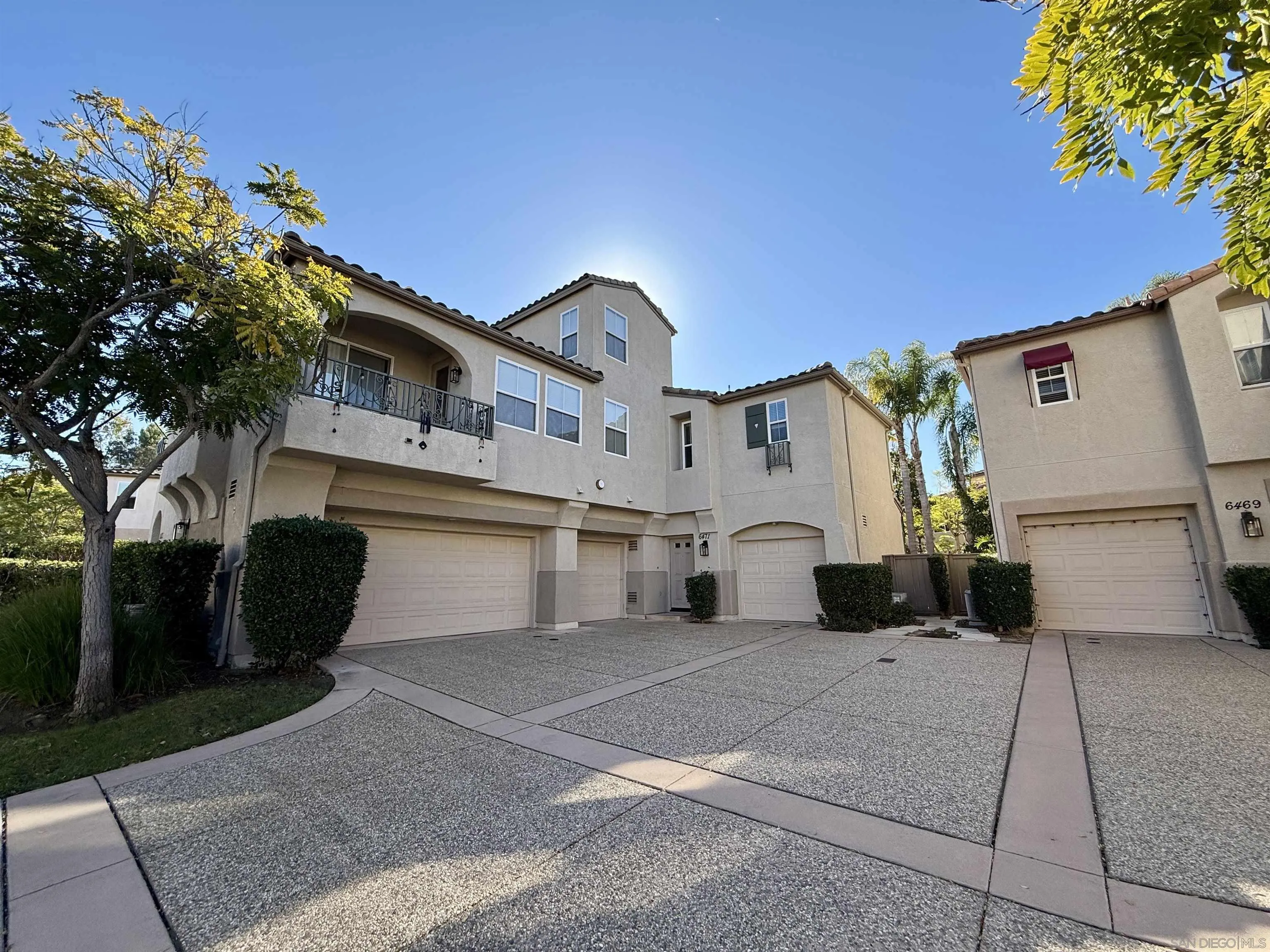 6471 Terraza Portico Carlsbad, CA 92009 - Photo 17 of 19 a view of a white house with a yard and a large tree
